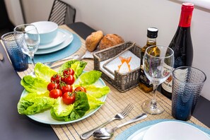 Una mesa puesta con ensalada, copas de vino y pan.
