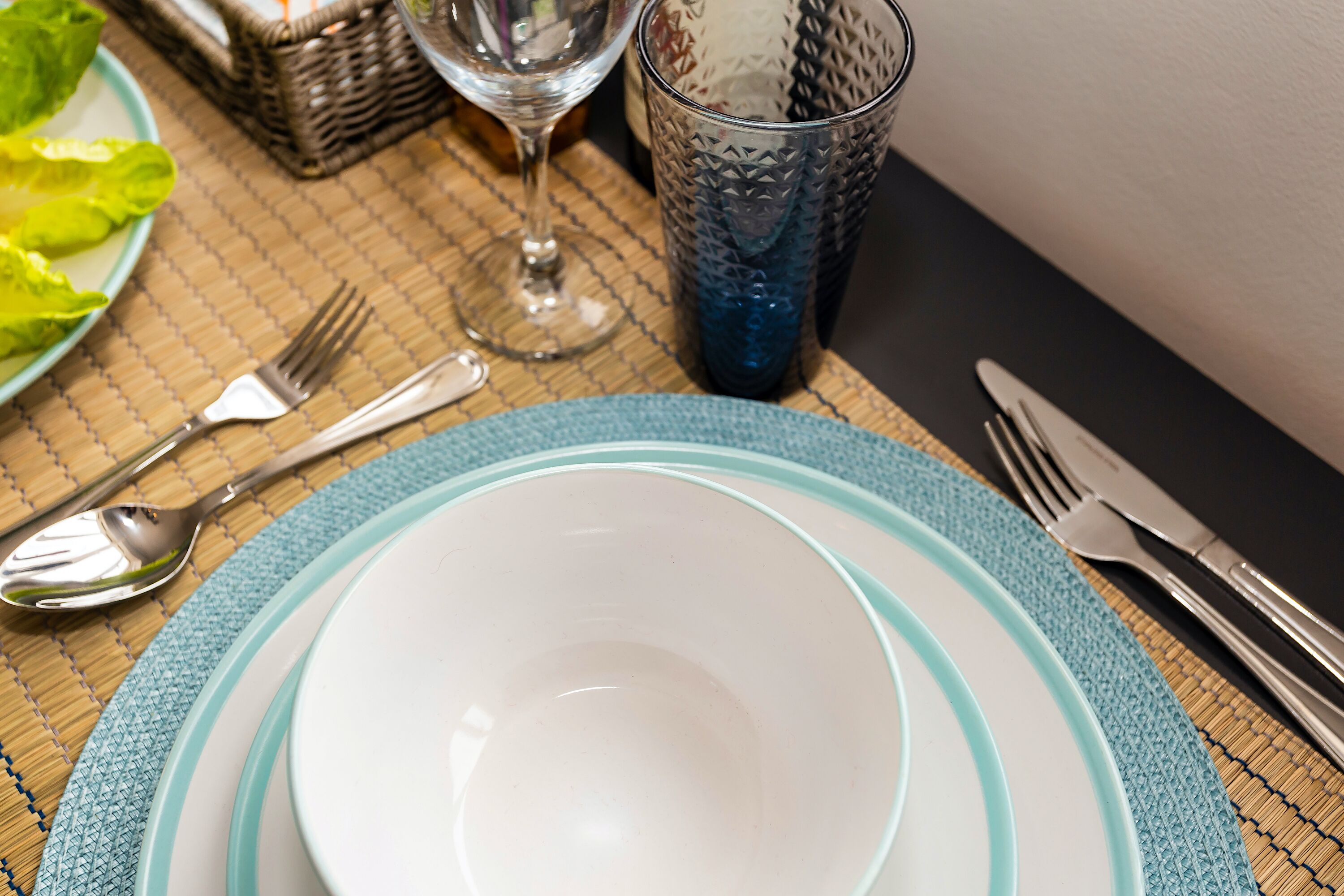 A table set with plates, cutlery, and a glass.