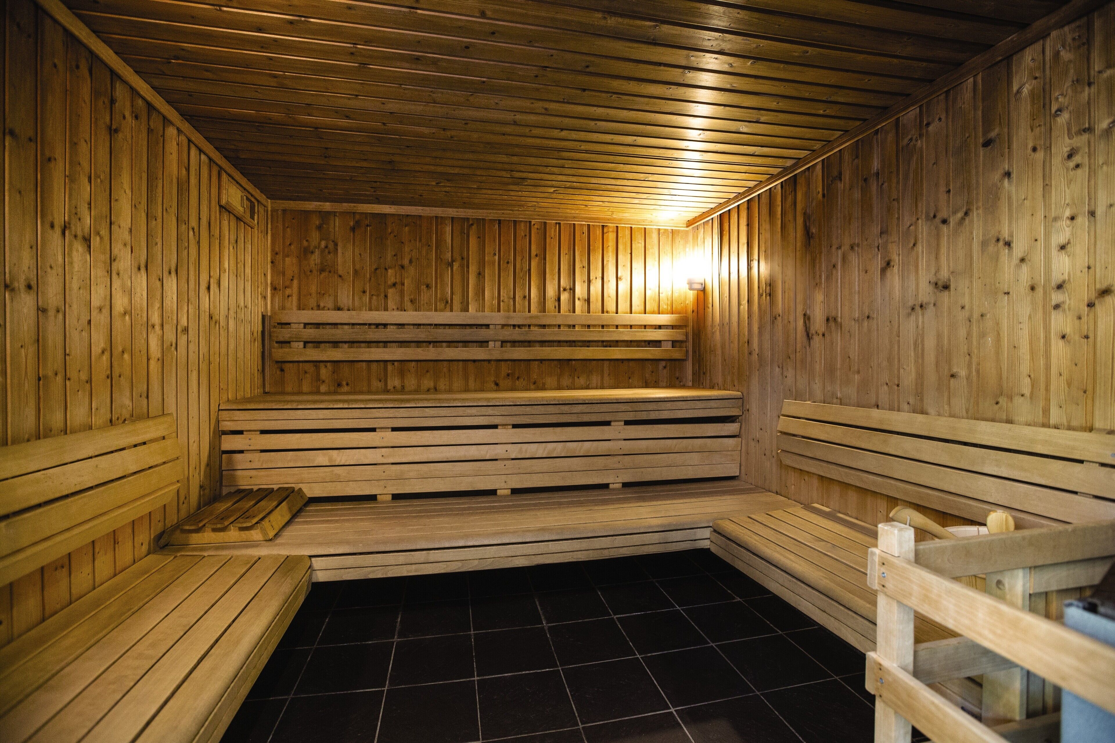 A sauna with wooden benches and a tiled floor.