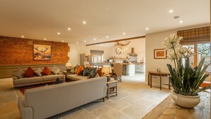 A spacious living area with a sofa, coffee table, and a potted plant. - Red Stag Lodge, Little Massingham, Norfolk (Little Massingham)