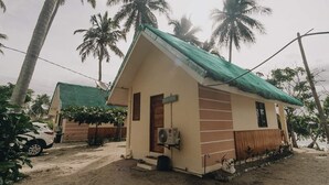 Un petit bâtiment d’un seul étage, doté d’un toit végétalisé et entouré de palmiers.