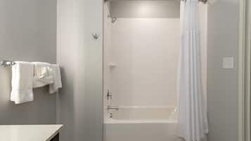A bathroom with a bathtub, shower curtain, and towel rack.
