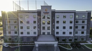 Ein mehrstöckiges Hotel mit Innenhof, Pool und Parkplatz.