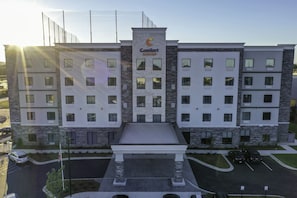 Ein mehrstöckiges Hotel mit Innenhof, Pool und Parkplatz.
