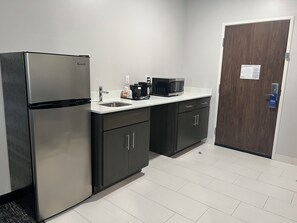 Een moderne keuken met een roestvrijstalen koelkast, een magnetron en een spoelbak.
