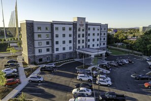 A multi-story hotel with a parking lot full of cars. - Comfort Suites Greenville Airport (Greenville)