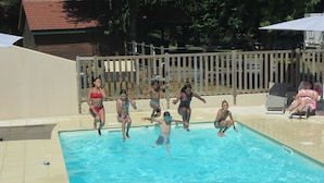 A swimming pool with people jumping into the water.