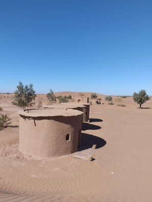 A desert landscape with traditional mud-brick structures. - Mhamid Tours (M'Hamid El Ghizlane)