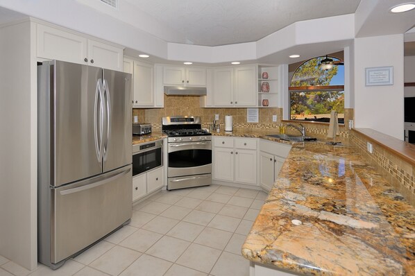 Enjoy cooking in this well-equipped kitchen with stainless steel appliances, double ovens, and ample storage.