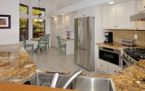 Enjoy meals in the kitchen with a refrigerator, oven, and gas stove, complemented by a dining area with a chair and table.