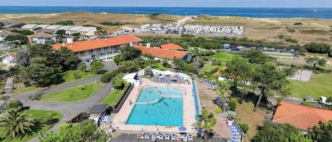 A resort with a swimming pool, beach view, and multiple buildings.
