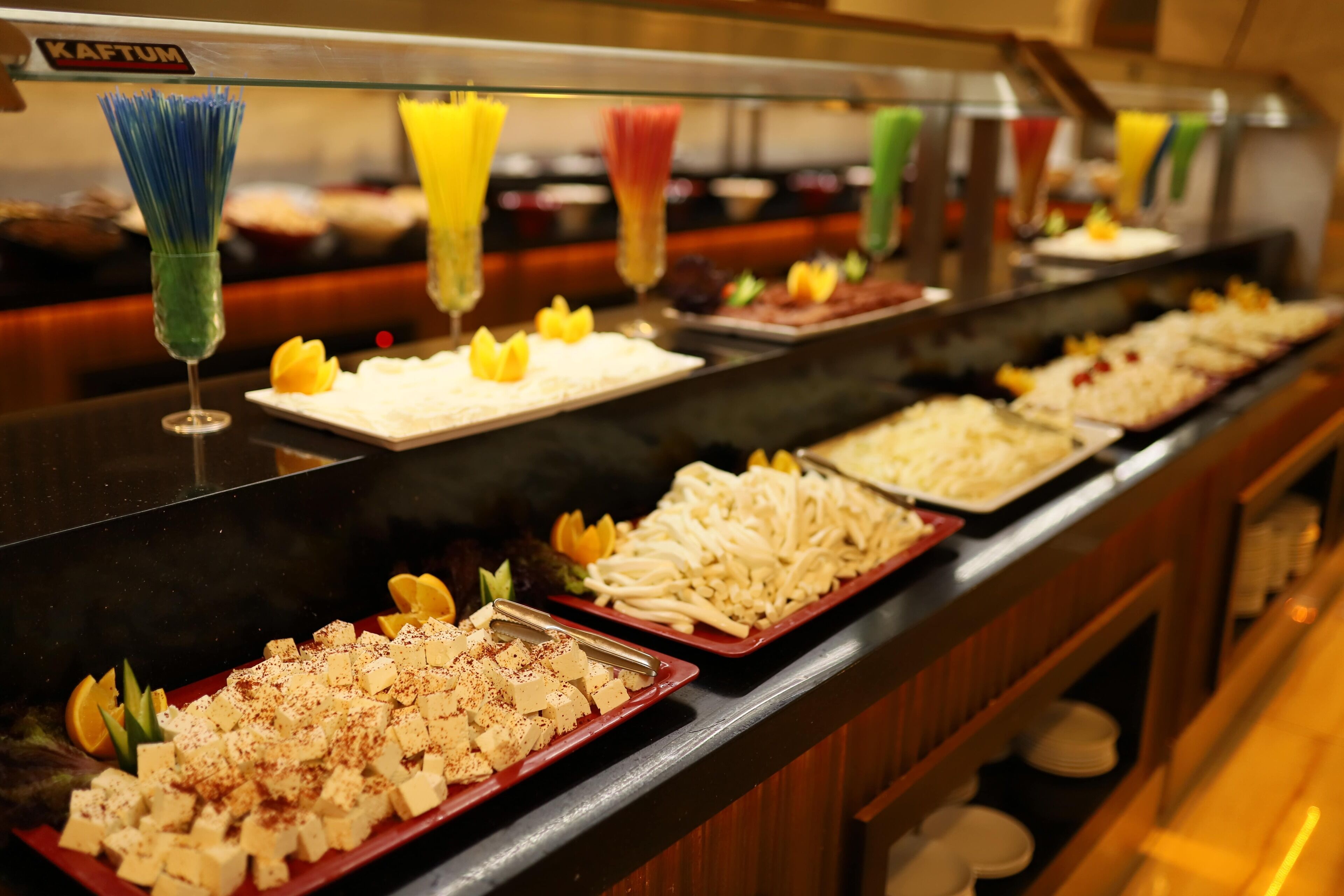 Een buffet met diverse soorten eten en kleurrijke drankdispensers.