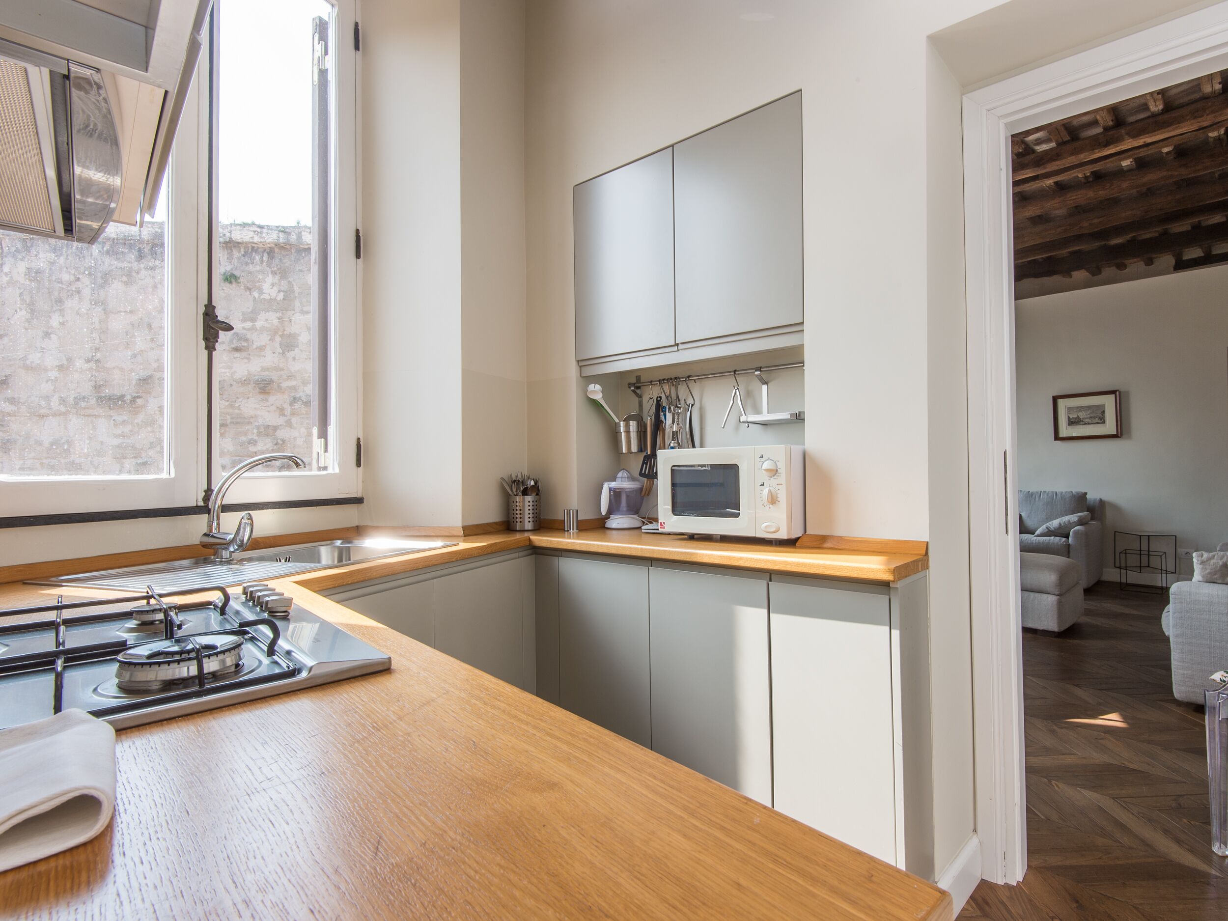 A compact kitchen with a wooden countertop, a built-in microwave, and a gas stove.