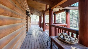 A wooden log cabin with a covered porch and a stone fireplace. - Secluded, Spacious, Close to Town, Large Lot, Great Family Home, Hot Tub (Pagosa Springs)