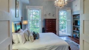 A bedroom with a large bed, a dresser, and a chandelier. - The Sarah Elizabeth House on beautiful Jones St w/ Private Courtyard (Savannah)