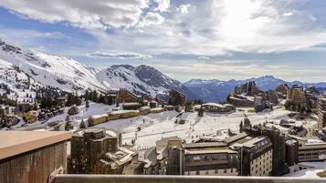 Une ville de montagne enneigée, avec des bâtiments historiques et une piste de ski.