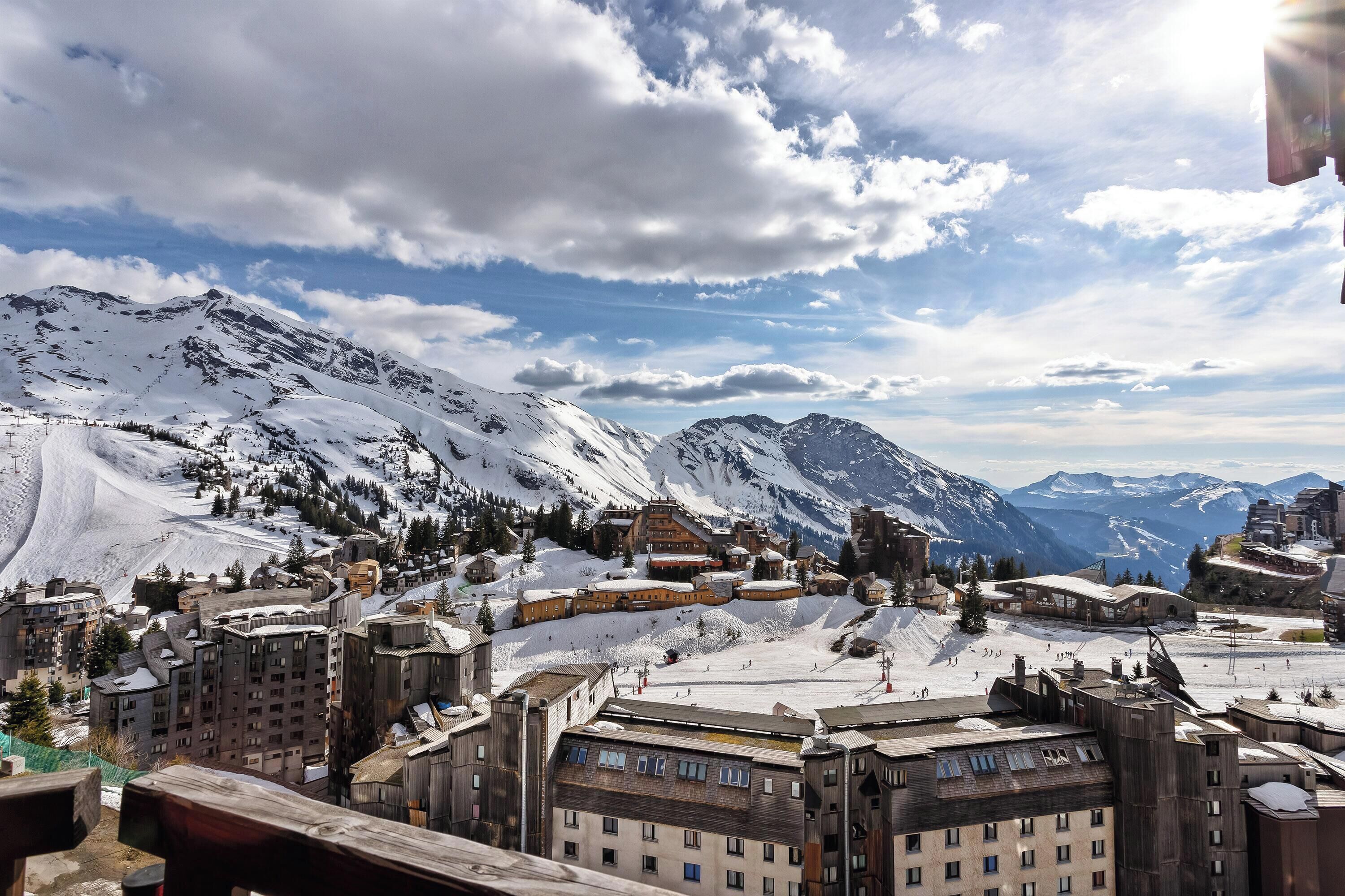 Une ville de montagne aux pentes enneigées et aux bâtiments recouverts de neige.