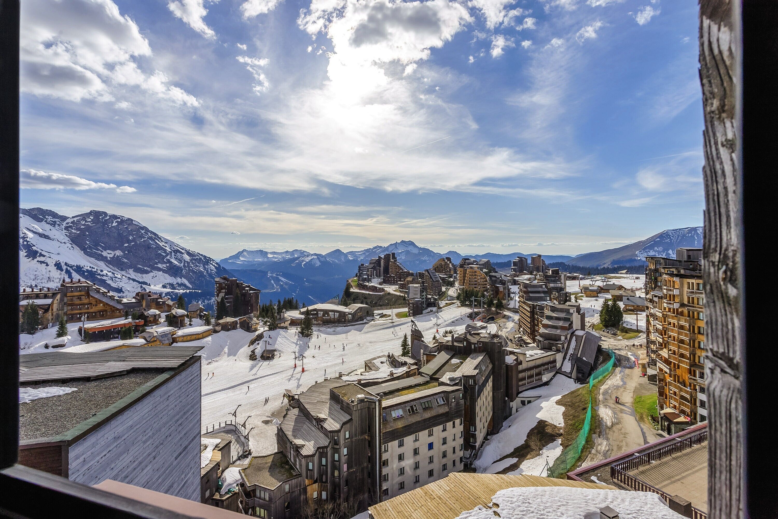 A snow-covered mountain town with buildings and a ski slope.