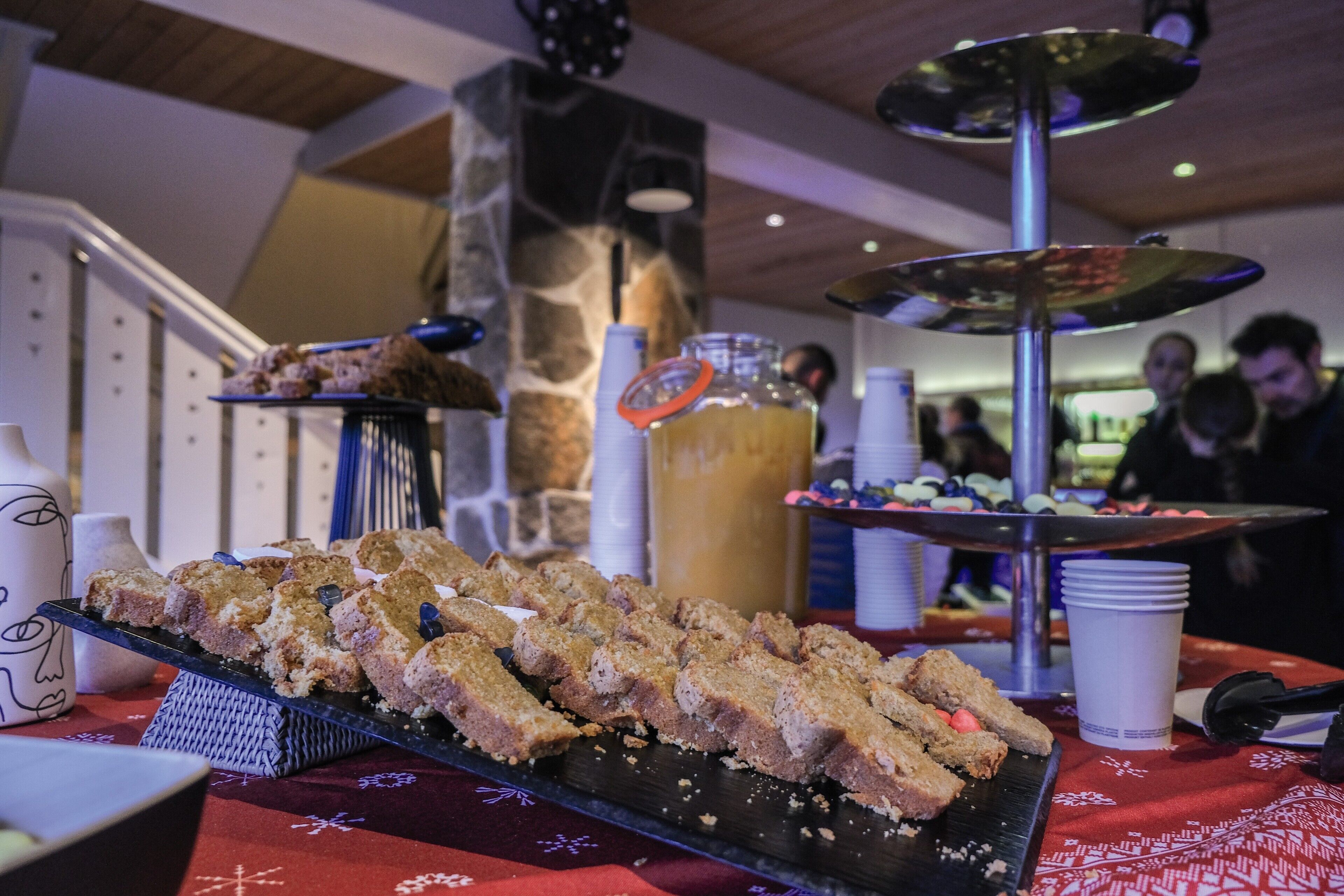 A buffet table with various food items and a beverage dispenser.
