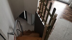Una escalera de madera con barandillas de metal que conduce a una plataforma.