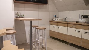 Una cocina con armarios blancos, encimeras de madera y taburetes.
