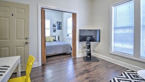 Un dormitorio con cama, televisor y ventana con persianas.