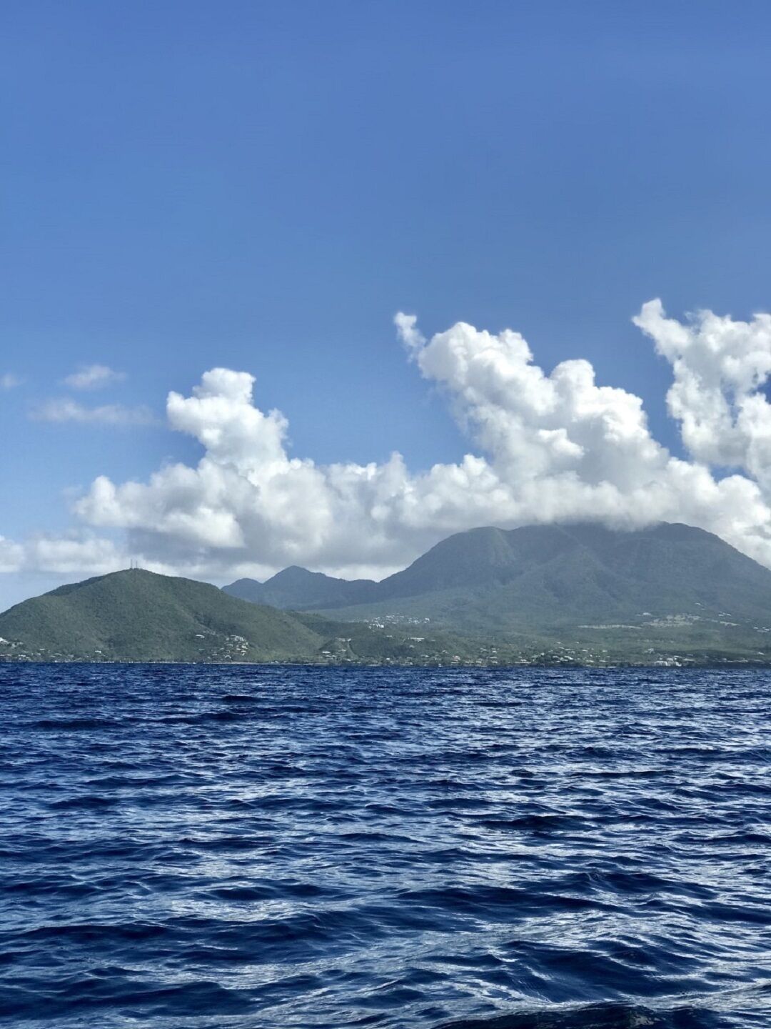A view of a mountainous island with a clear sky and calm sea.