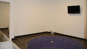 A bathroom with a bathtub, white walls, and a black and gold tiled floor. - D2 Ducal Apartment with private pool (Gandia)