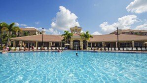 A large swimming pool with lounge chairs and umbrellas, surrounded by buildings with a tiled roof and palm trees. - Spacious and Lovely 3BD Unit With Balcony, Close to the Convention Center #3vc309 (Orlando)