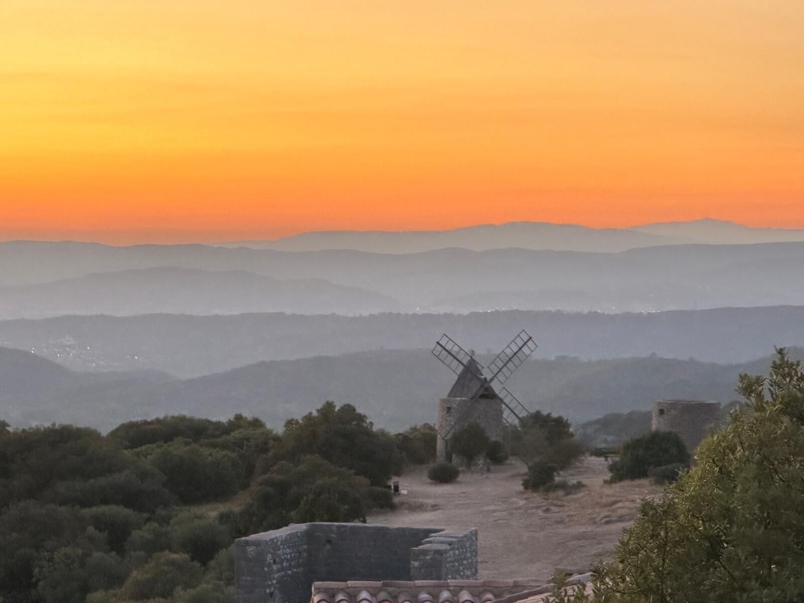 Un molino de viento en un paisaje montañoso con cielo despejado.