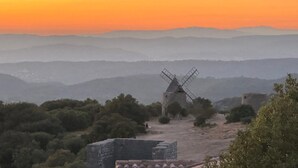 A windmill in a hilly landscape with a clear sky.