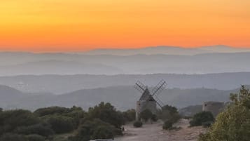 Un molino de viento en un paisaje montañoso con cielo despejado.