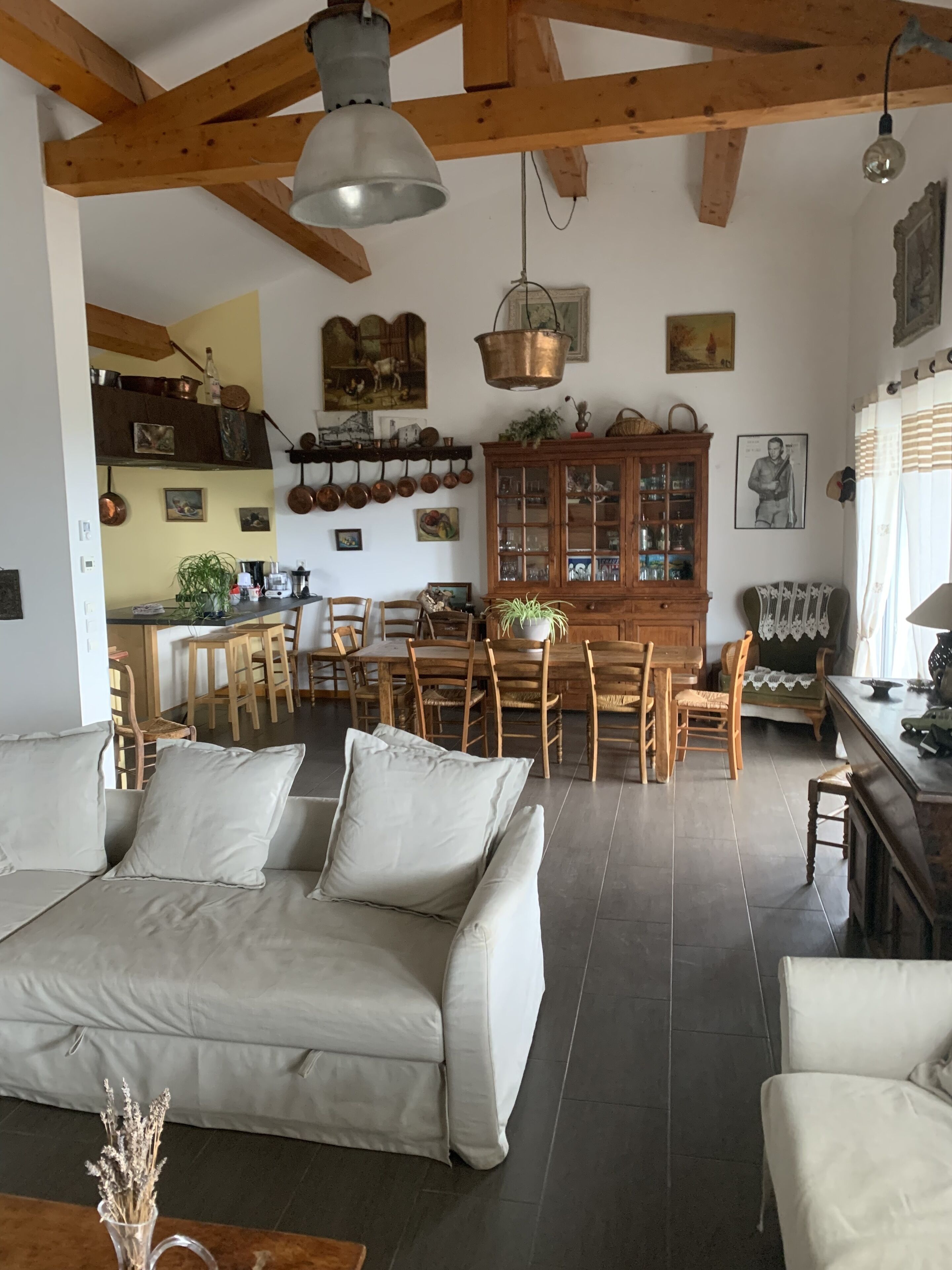 Un salón comedor amplio con sofá, zona de estar y cocina.