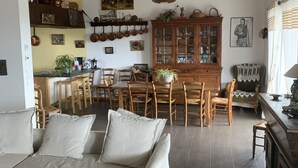 A spacious living room with a sofa, dining area, and kitchen.