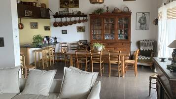 Un salón comedor amplio con sofá, zona de estar y cocina.
