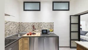 Une cuisine moderne dotée d’un îlot central, d’appareils électroménagers en acier inoxydable et d’un revêtement mural décoratif.