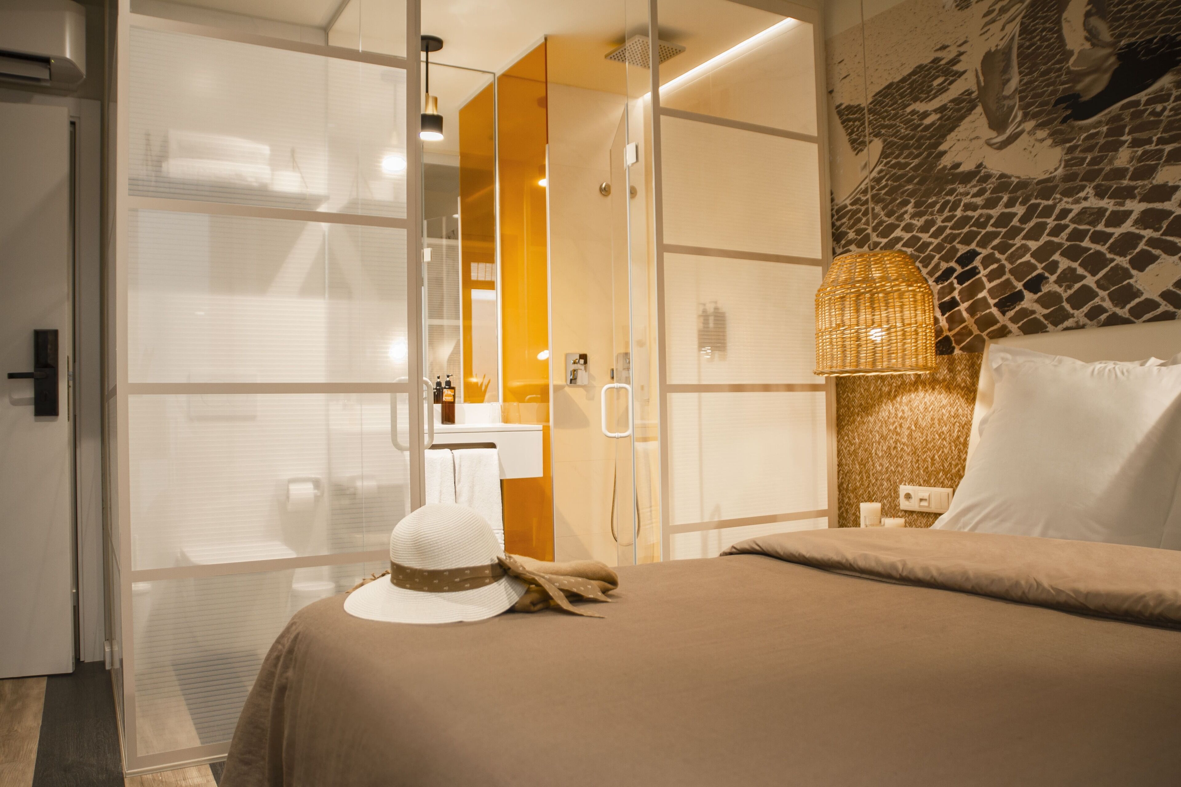 Une chambre d’hôtel comprenant un lit, une armoire, une salle de bain et un mur orné d’un motif en mosaïque.