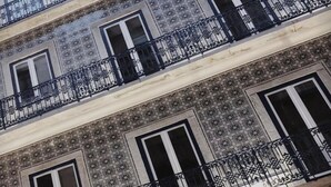 Un edificio a più piani con balconi caratterizzati da elaborate ringhiere nere.