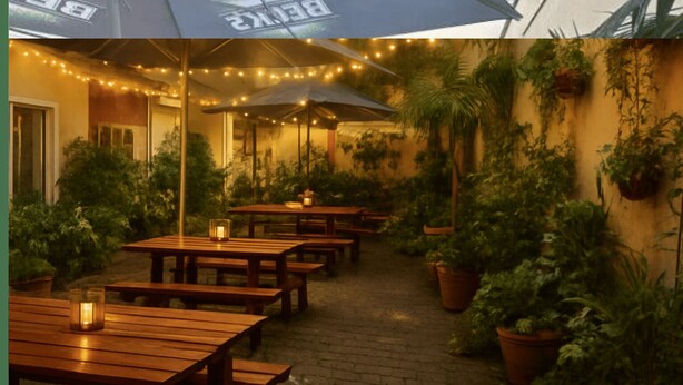An outdoor patio with wooden tables and benches, string lights, and potted plants. - Apartment Osterstraße 347 (Hannover)