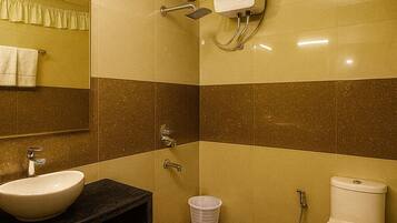 A bathroom with a sink, mirror, toilet, and shower.