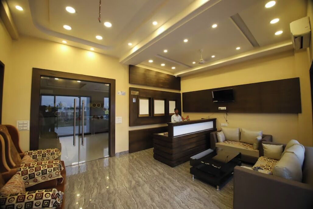 A hotel lobby with a reception desk, seating area, and a large window.