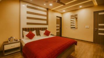 Una habitación de hotel con cama, mesita de noche y espejo en la pared.
