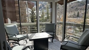 A balcony with a table and chairs, offering a view of a mountainous landscape. - Park City in the summer. Stay in completely remodeled condo close to Main Street (Park City)