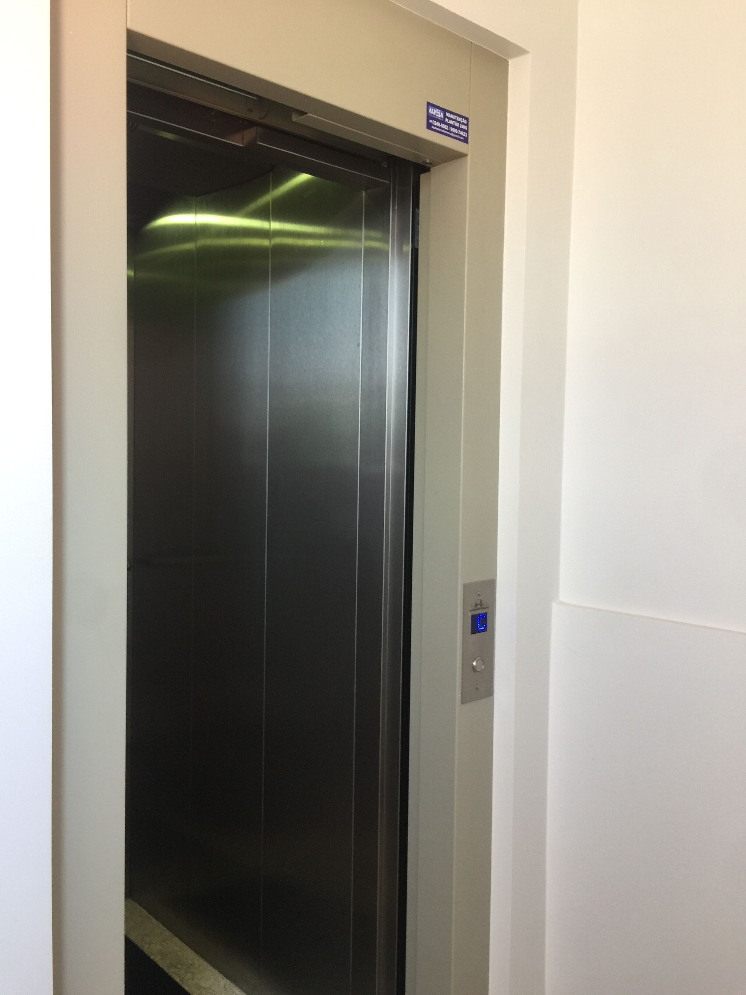 Um elevador com visor digital e um sinal acima.