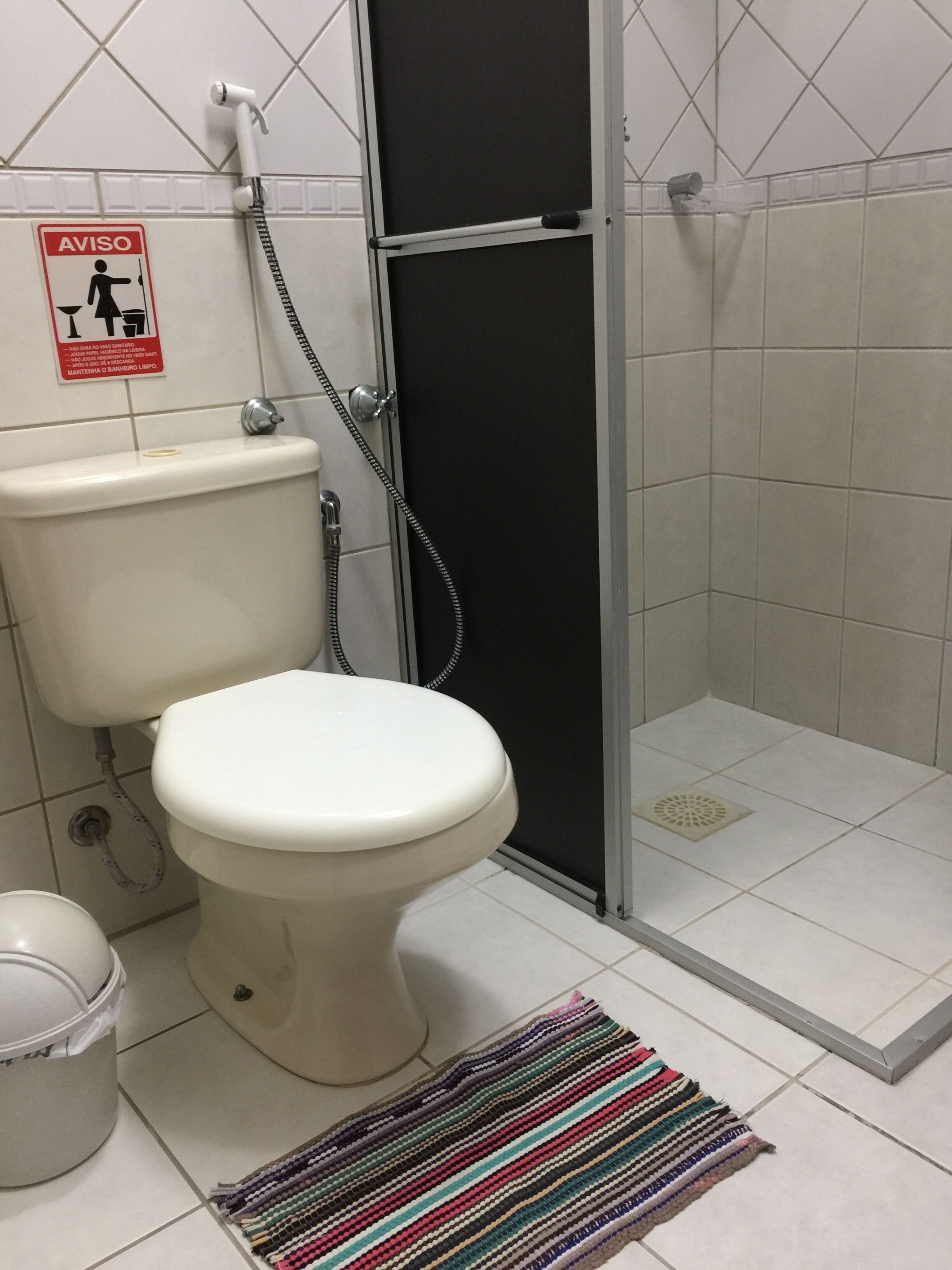 Un baño con inodoro, ducha y secador de manos.