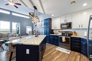 Enjoy cooking in this well-equipped kitchen with a central island, oven, and microwave.