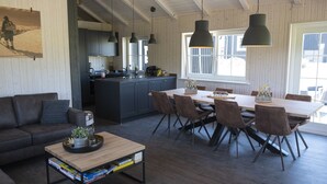 Una sala de estar moderna con sofá, mesa de centro y comedor con sillas y una mesa.