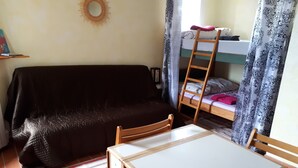 A small room with a sofa, a bunk bed, a table, and chairs. - For nature lovers (SAINT MARTIN DE PALLIERES)