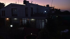 Un edificio moderno de dos pisos con techo plano, ventanas amplias y fachada de piedra.