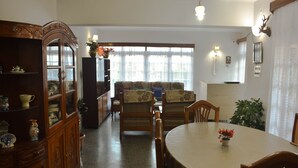 Un comedor con una mesa redonda, sillas y un aparador con puertas de vidrio.